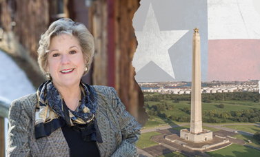Dr. Crimm smiles at the camera; on the right is the San Jacinto Monument.