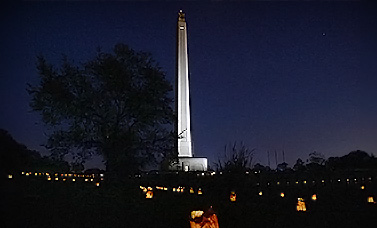 Luminaria light the fields surrounding the San Jacinto Monument at night.