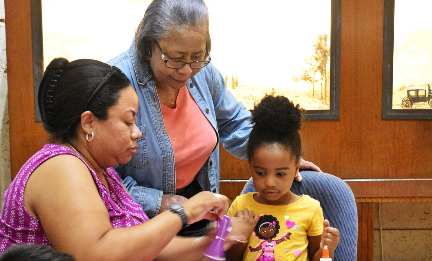 Three generations work on a craft project.