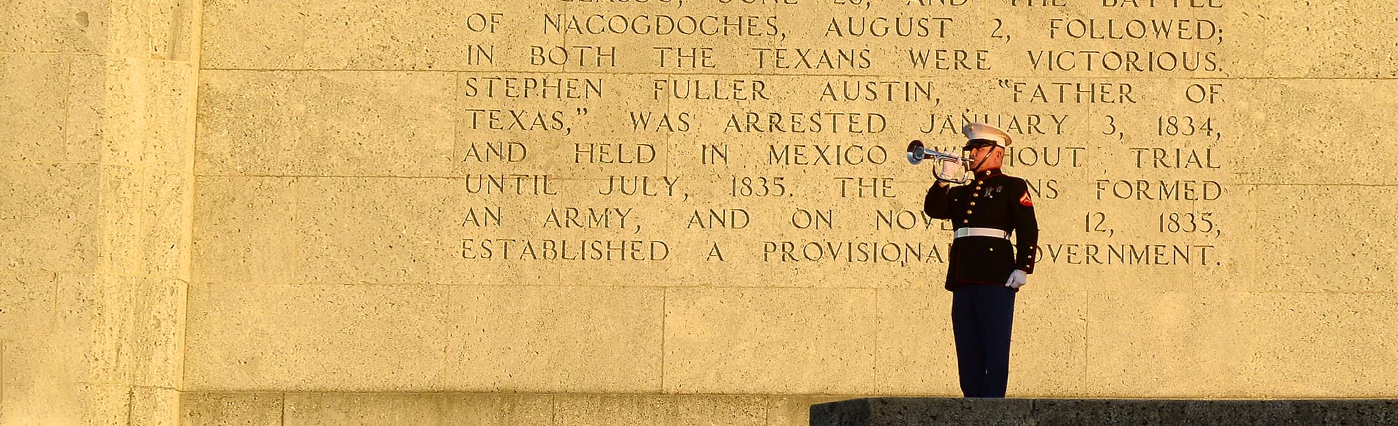 A marine blowing into a trumpet at the San Jacinto Monument