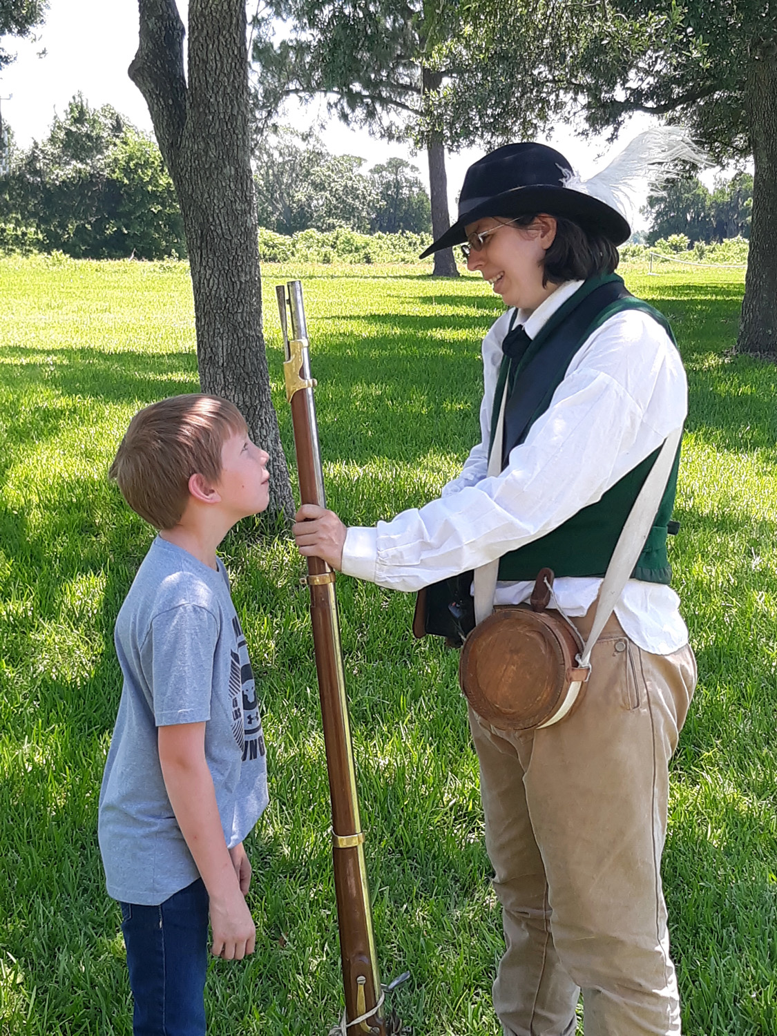 An educator shows a reproduction weapon to a child.