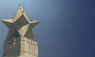 The top of the San Jacinto Monument against a darkening sky.