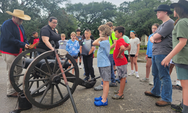 Educators show children how a cannon is used.
