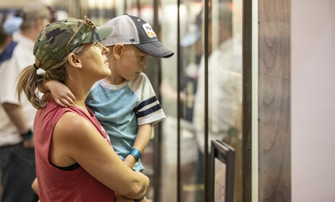 A woman and child look at a museum exhibit.