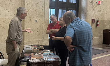 An author talks with museum members about history.