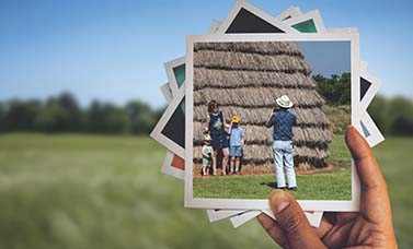 A hand holds up s stack of snapshot photos.