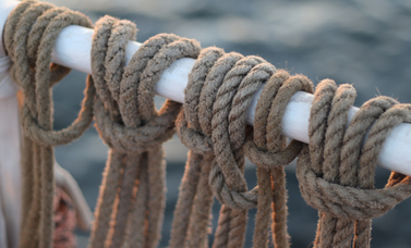 Several ropes hang from a pole.