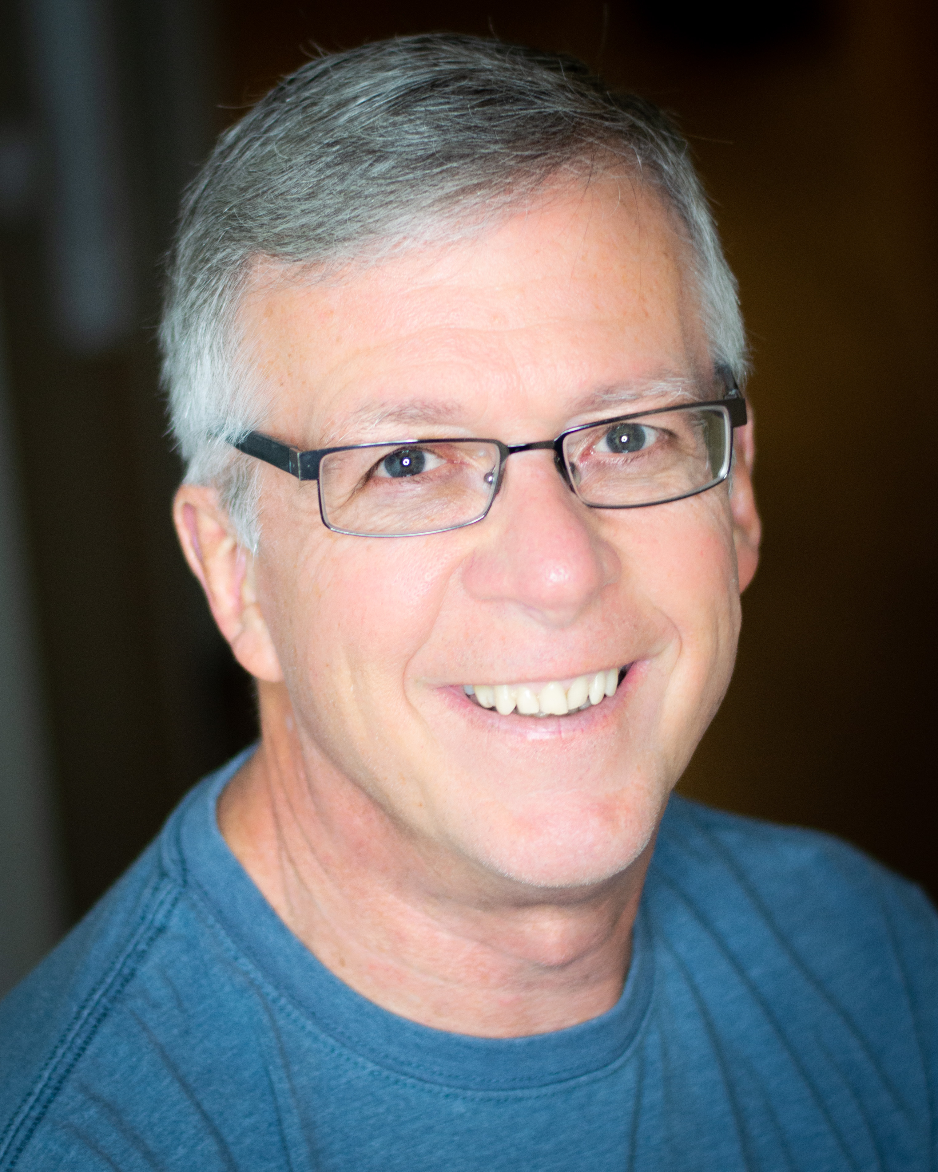 Head and sholders of Greeg Dimmick, wearing a blue shirt.
