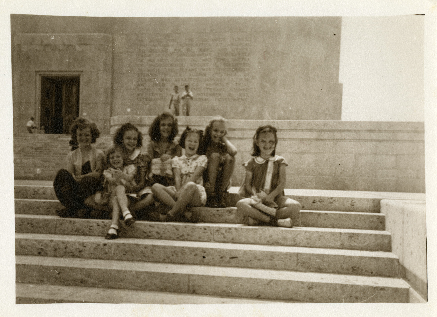 Seven little girls smile at the camera from the steps of the San Jacinto Monument.