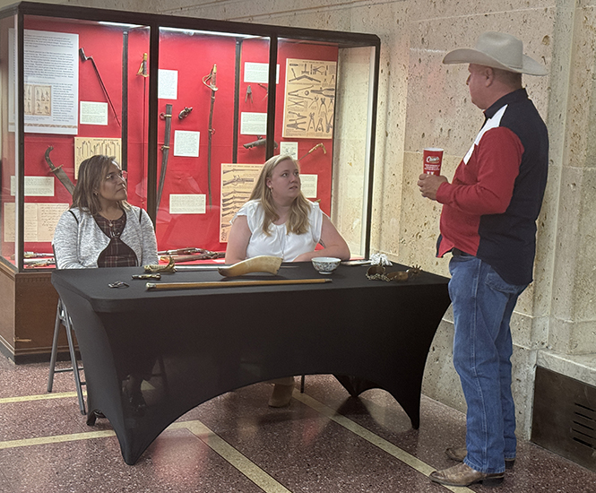 A man discusses artifacts with museum staff.