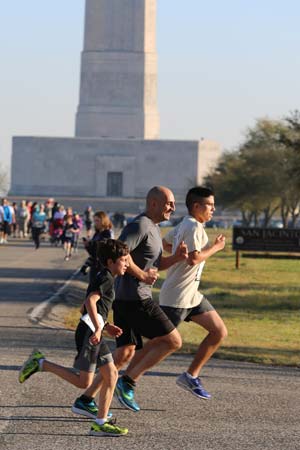 A boy and two adult men running at the San Jacinto 5K Fun Run